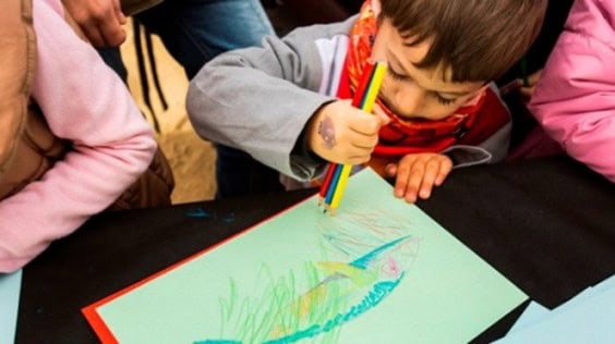 Niño participando en un taller infantil de dibujo durante el Carnaval de Barcelona.