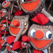 Troncos decorados como Caga Tió con caras sonrientes y barretinas rojas.