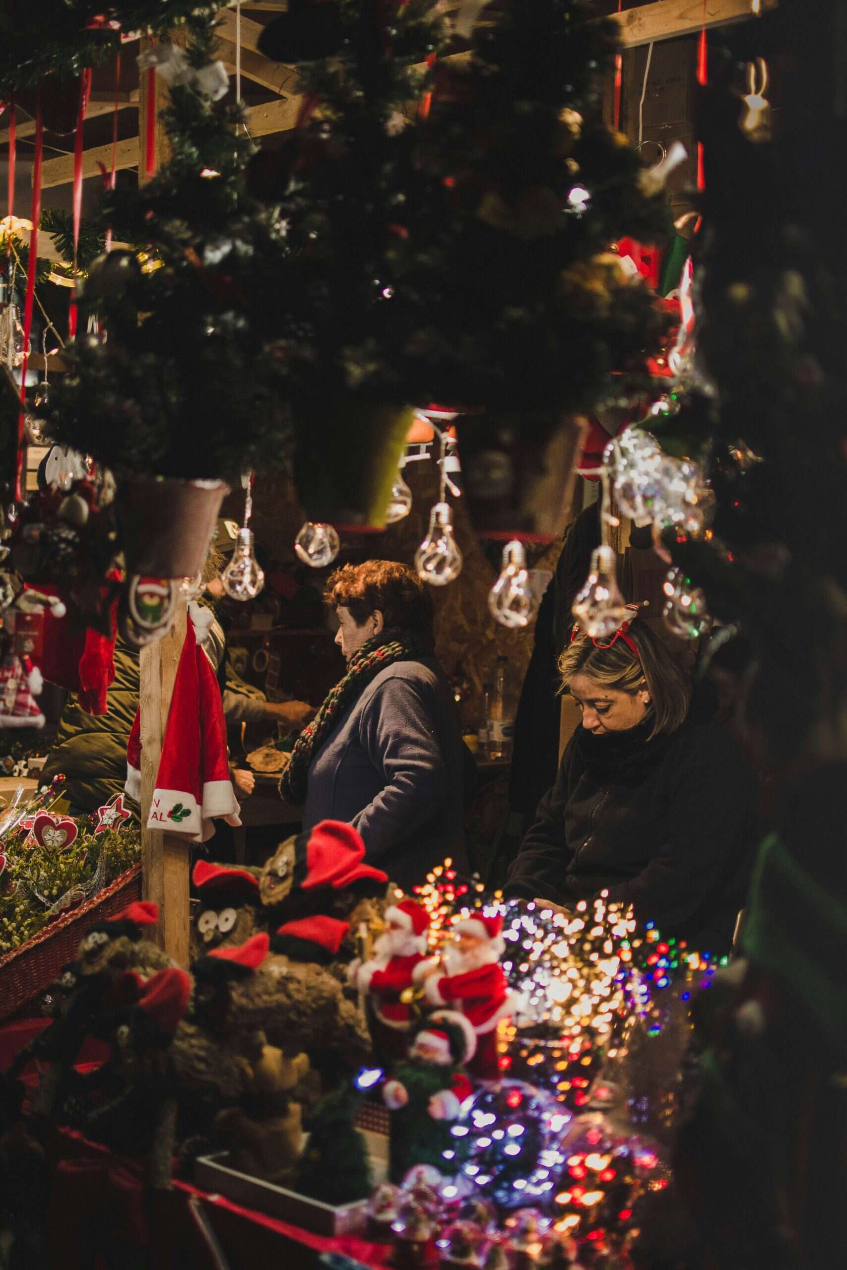Puesto navideño en un mercado de Barcelona con decoración, luces y figuras tradicionales.