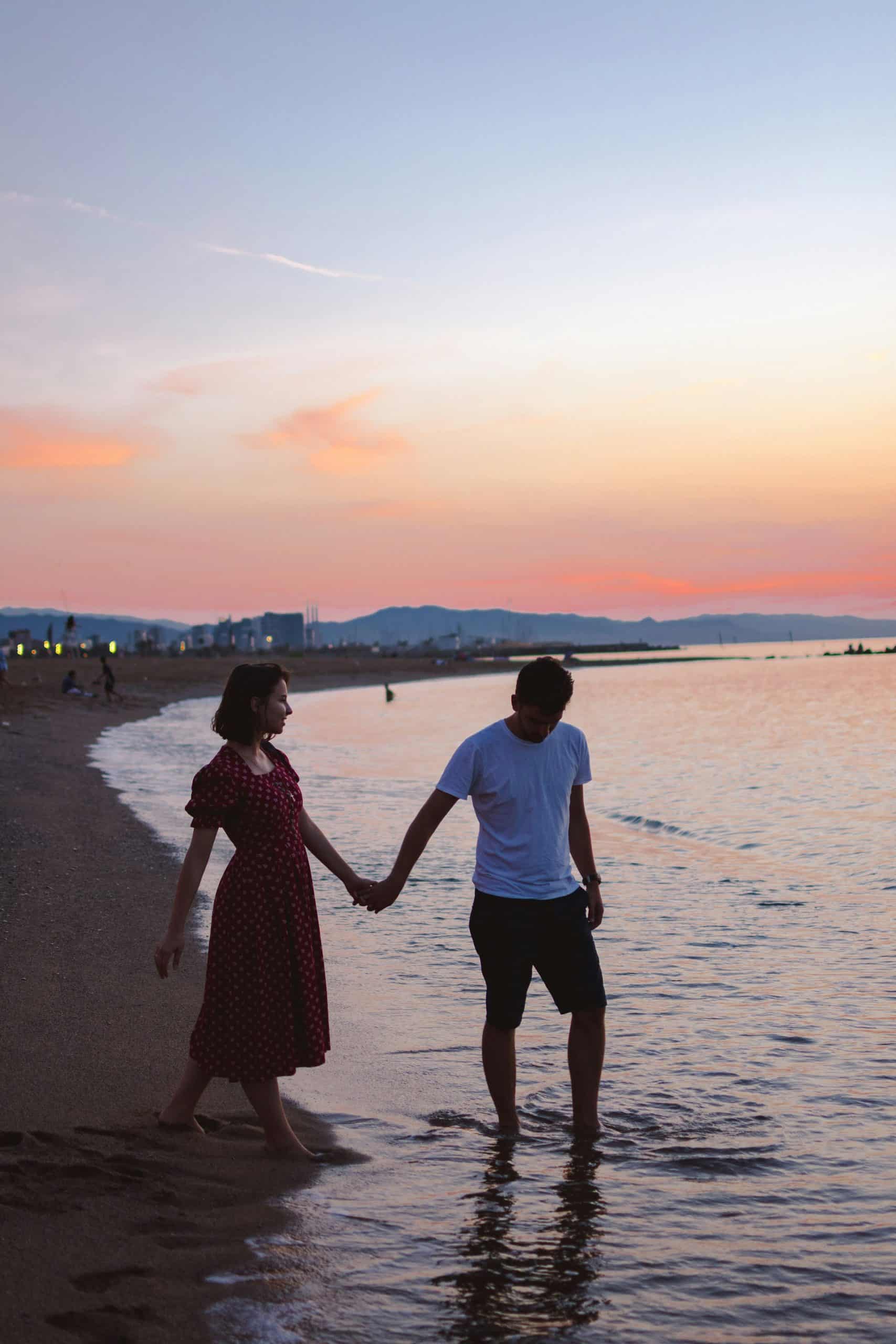 Pareja paseando al atardecer por la playa de Barcelona.